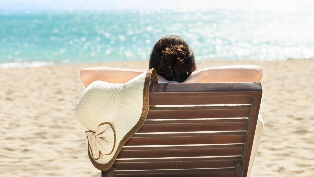 Tomar el sol Una mujer toma el sol tumbada en una hamaca.
