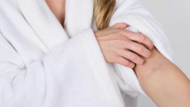 Mujer rascandose el brazo. Mujer rascandose el brazo.