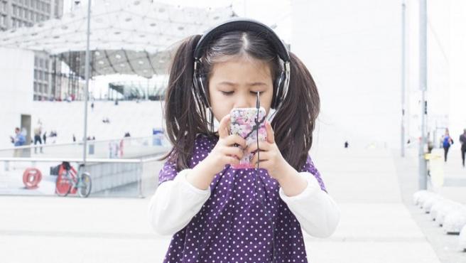 Una niña pequeña con un movil.