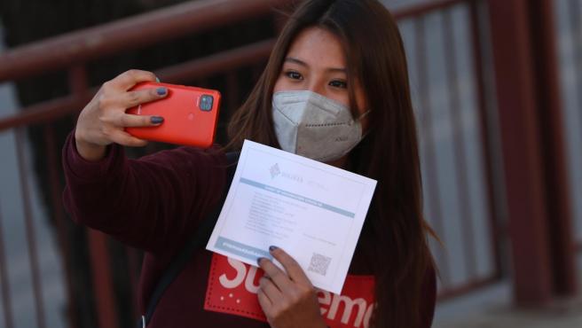 Una joven se hace una foto con su certificado de vacunacion contra la covid-19, en La Paz. Bolivia.