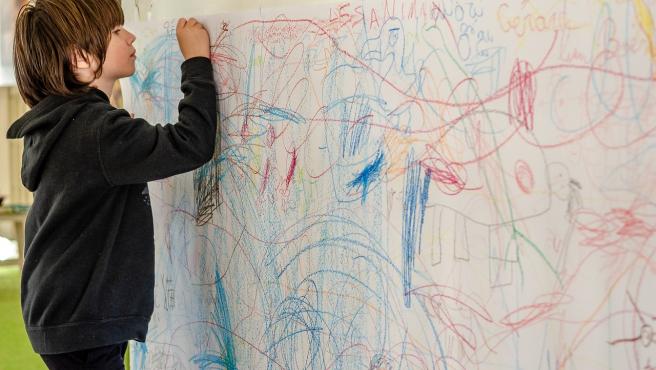 Un niño pintando una pared.