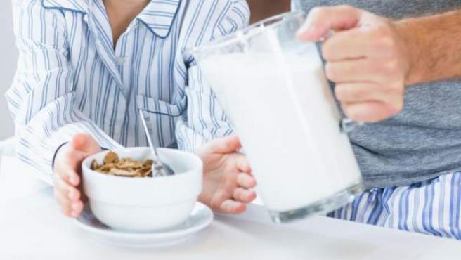 Imagen de un niño desayunando cereales y leche.