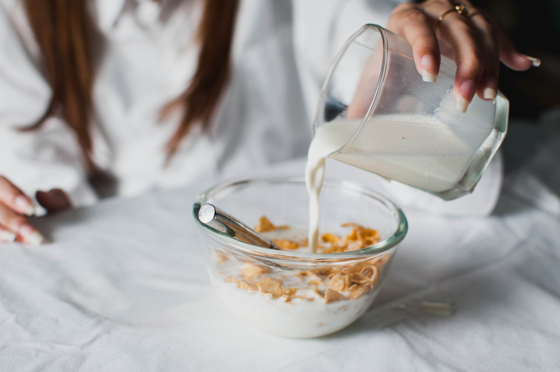 Una mujer se prepara un bol de cereales con leche para desayunar.