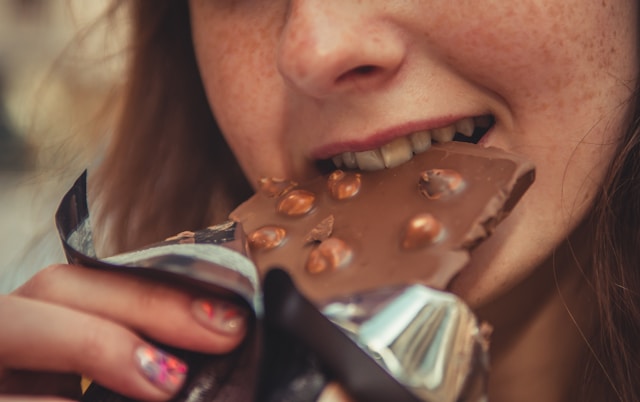 Mujer comiendose una tableta de chocolate