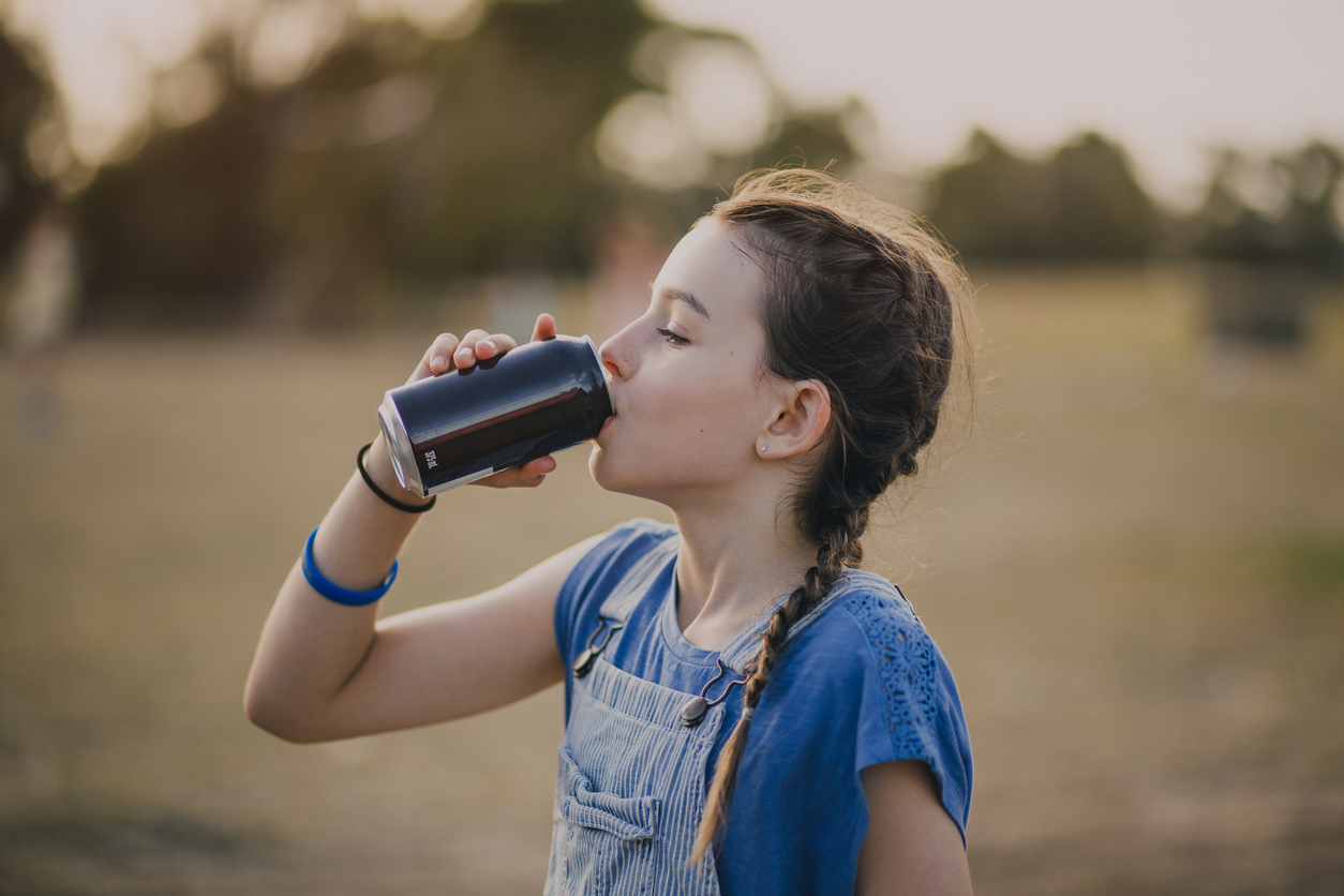 Una niña tomando un refresco.