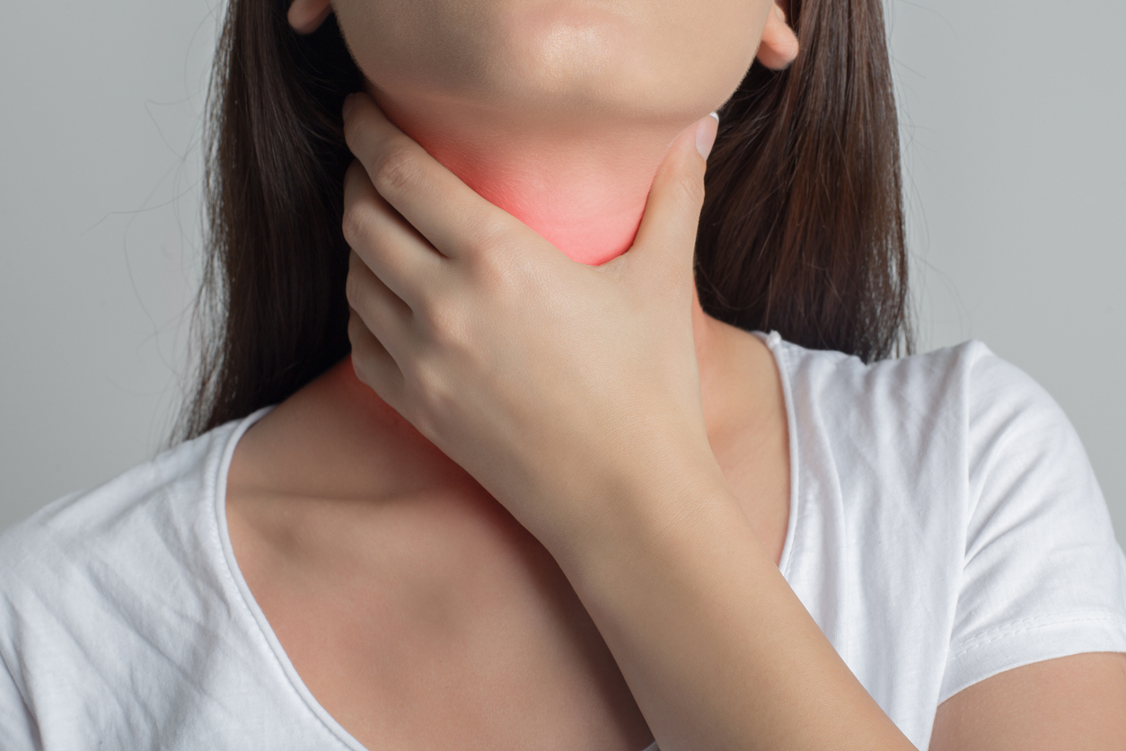 Mujer siente dolor en la garganta.