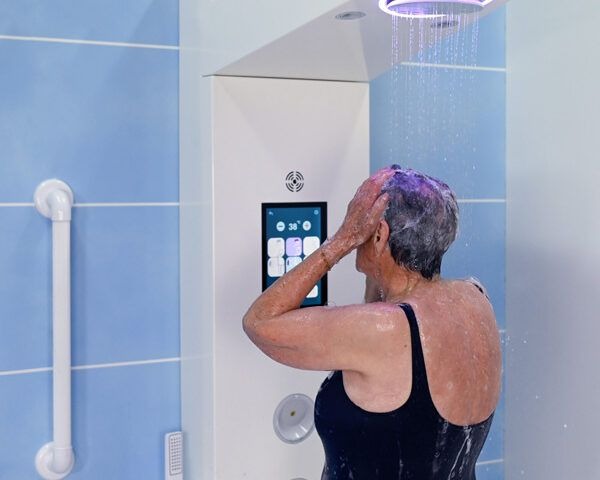 Persona mayor duchándose en una cabina Showee