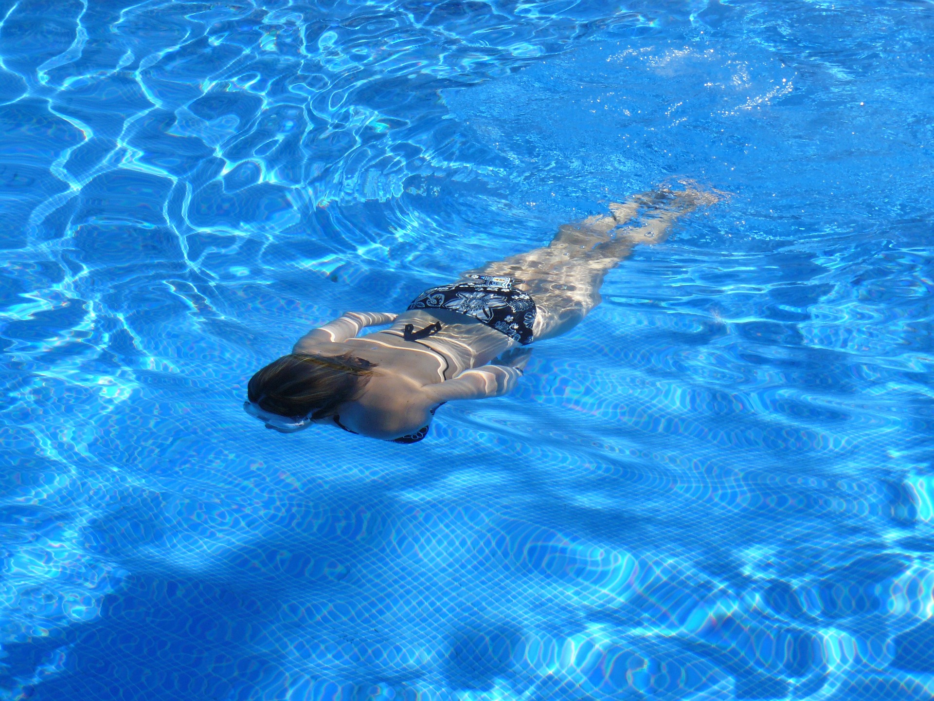 Una mujer nadando en una piscina.